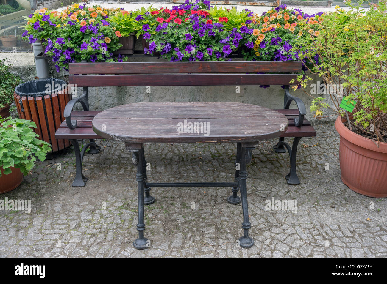 Banc de parc et une table entourée de fleurs Banque D'Images