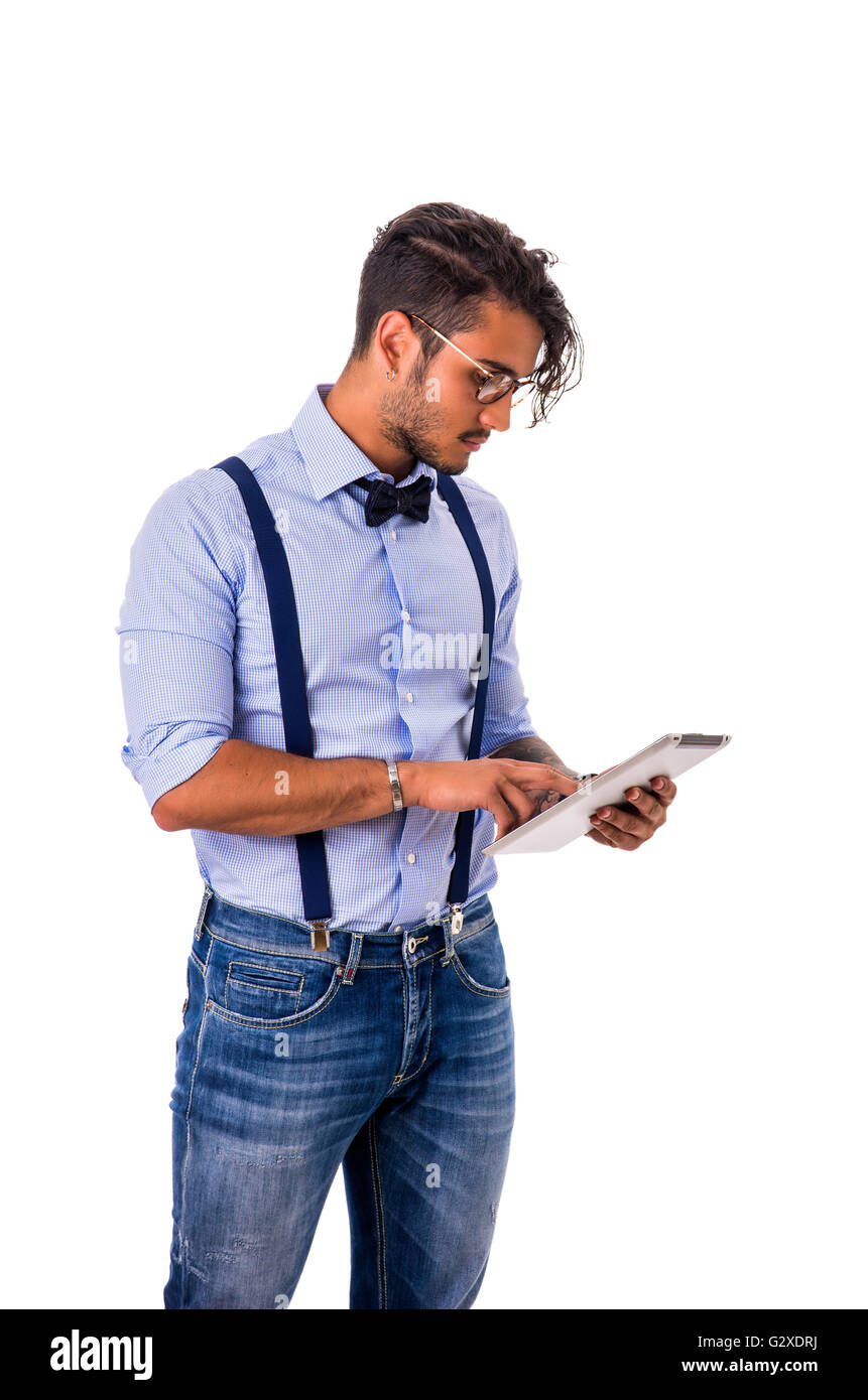 Portrait de jeune femme brune homme en chemise bleue, bretelles et jeans, à  l'aide de Tablet PC, standing in studio shot isolé agai Photo Stock - Alamy