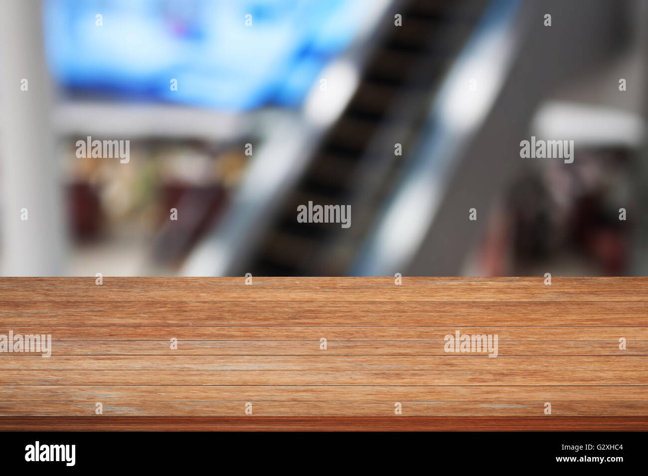 Haut de table en bois avec arrière-plan flou d'escalator in Airport Banque D'Images