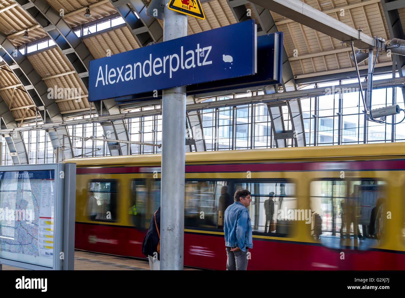 Un homme sur la plate-forme en train S-Bahn arrive à la gare Alexanderplatz dans le quartier Mitte de Berlin, en Allemagne Banque D'Images