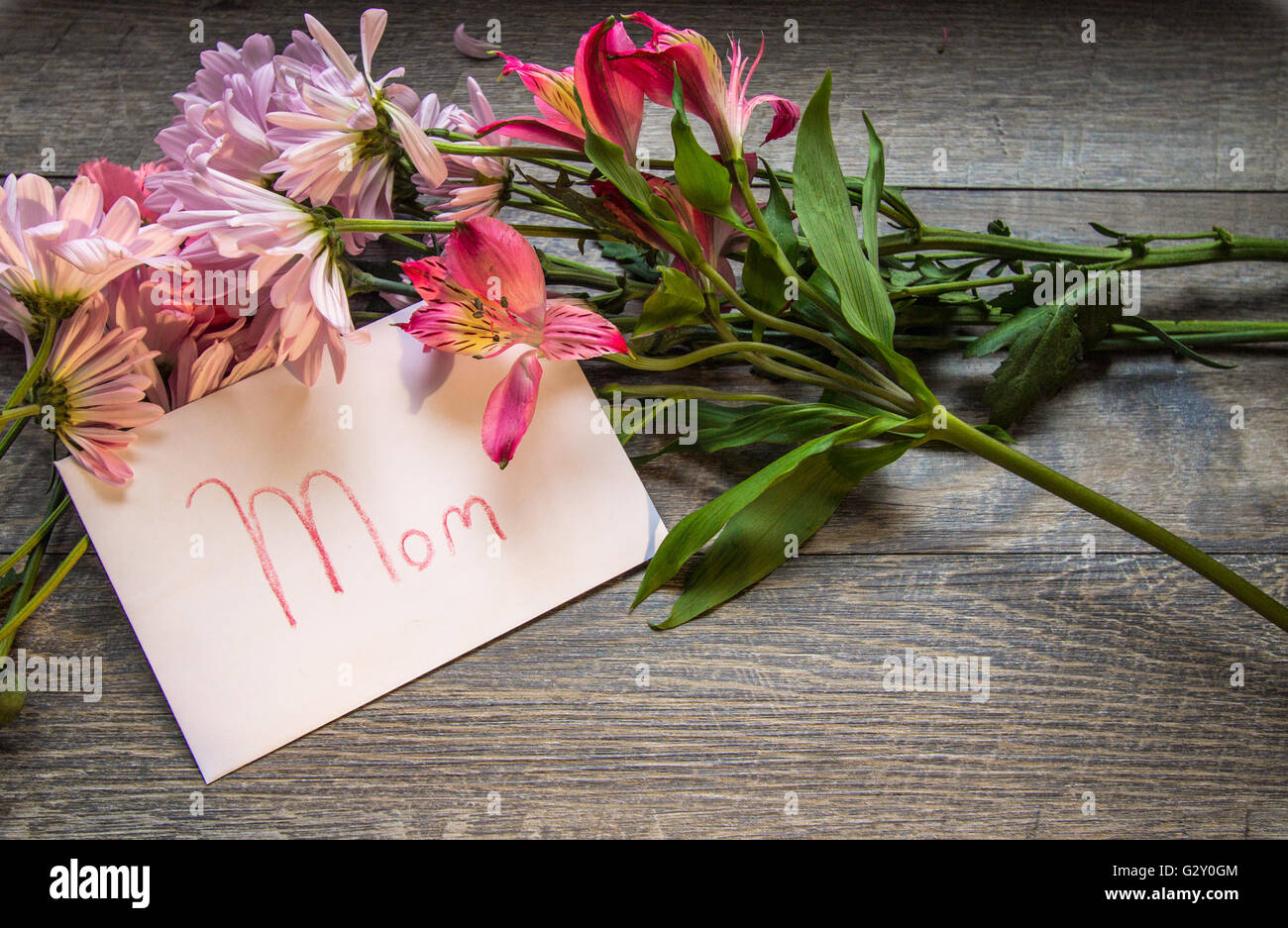 Bouquet Fête des mères et la carte. Bouquet Frais de Daisy, iris et d'oeillets avec une carte manuscrite appelée maman. En plongée des o Banque D'Images