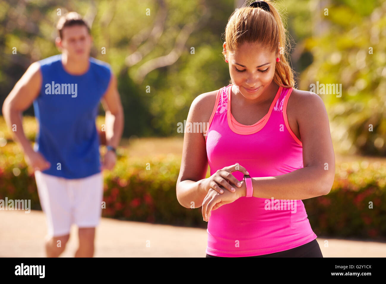 Des jeunes faisant du sport, fille et ami masculin en fonctionnement, avec fit watch, homme et femme, le jogging dans la rue. Concept Banque D'Images