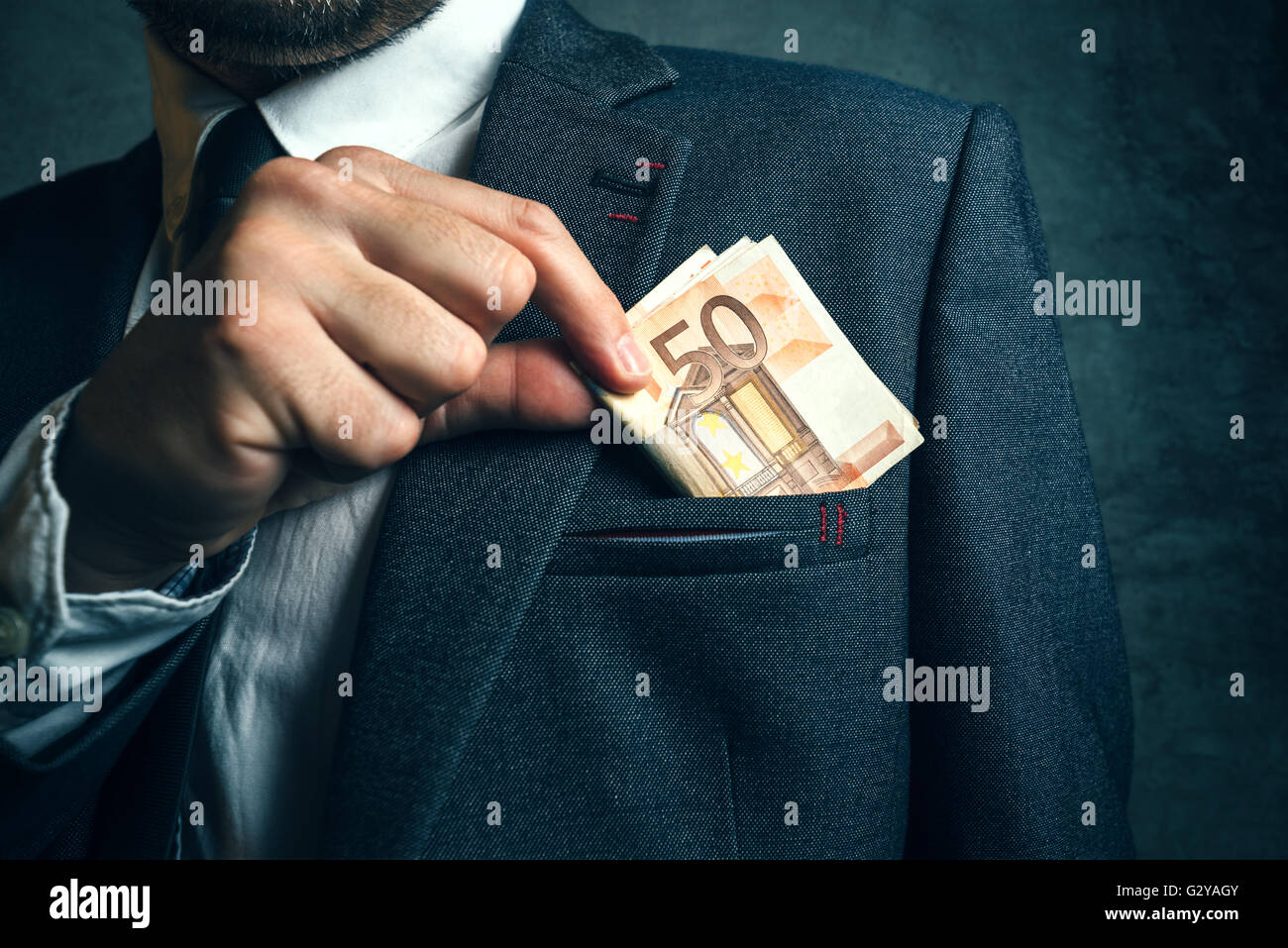 Businessman putting billets d'argent dans son costume d'affaires élégant, poche avec de l'argent comptant. Banque D'Images