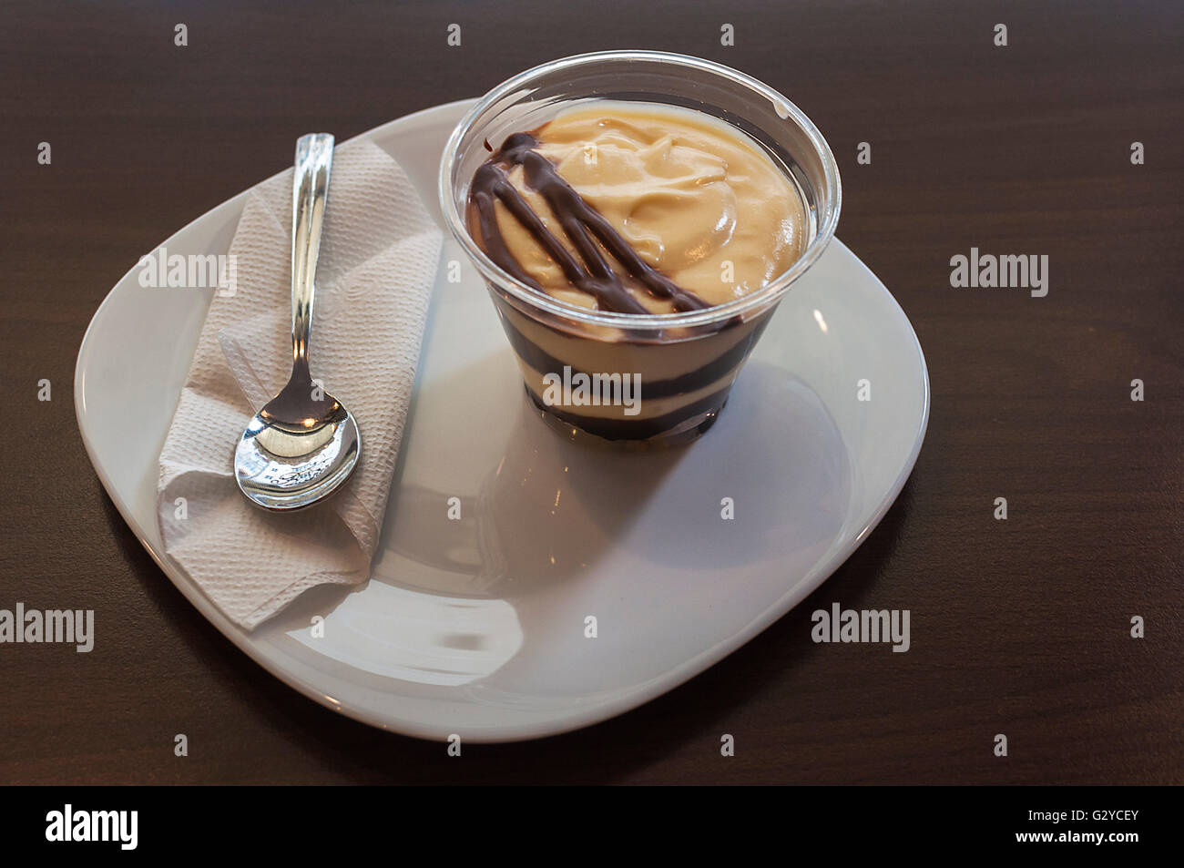 Un profiterol, une cuiller et une serviette sur une plaque Banque D'Images