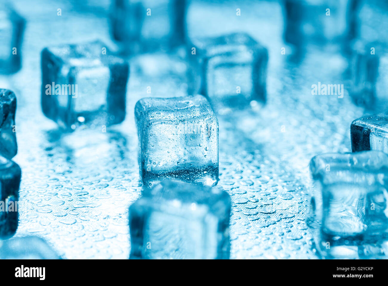 De nombreux cubes de glace fondante bleu sur verre Banque D'Images