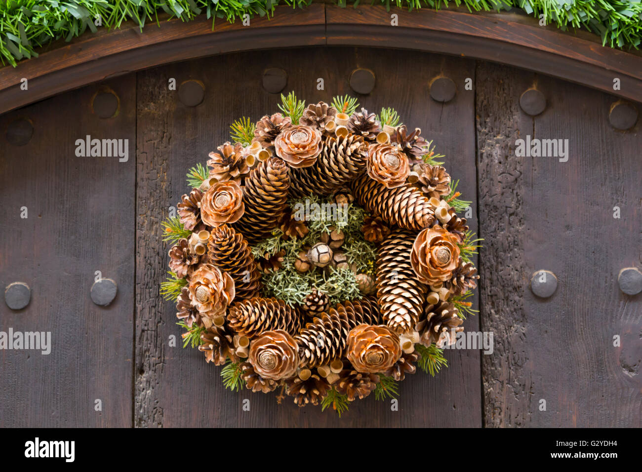 Couronne, avec cocottes, accroché dans une porte en bois Banque D'Images