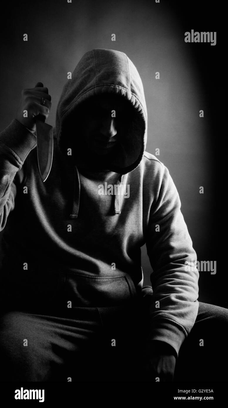 Intimidant hooded homme tenant un couteau Banque D'Images