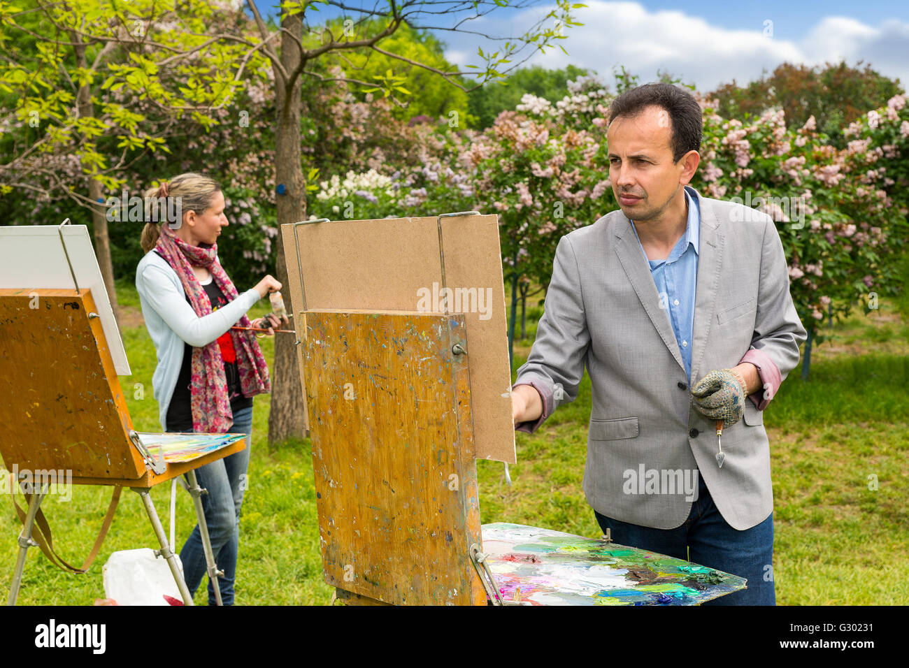 Peintres, hommes et femmes travaillent avec leurs chevalets holding paintbrush et la peinture en plein air Banque D'Images