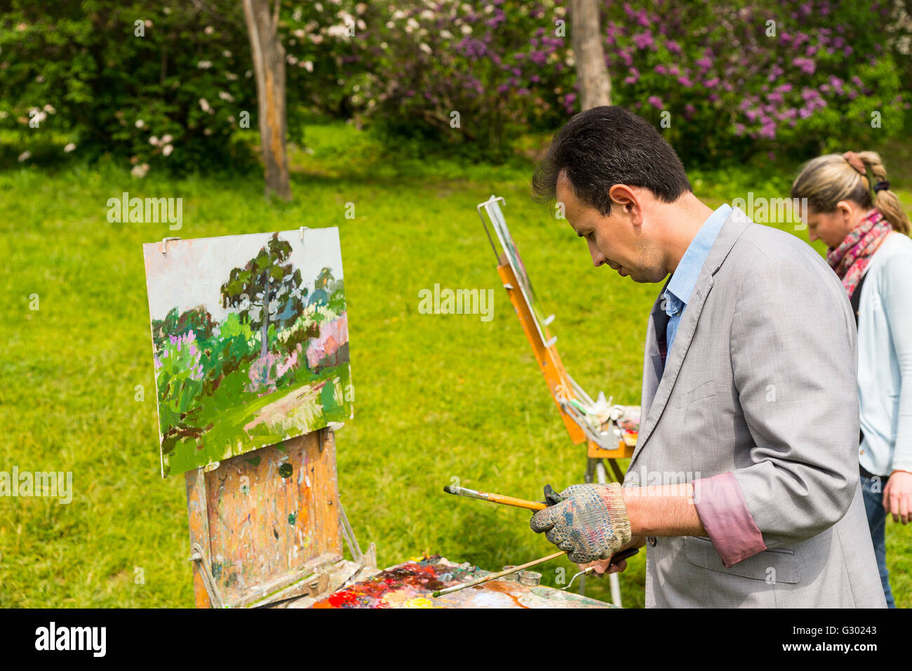 Peintres, hommes et femmes à l'extérieur Peinture Peinture à l'huile et acrylique Peinture à l'extérieur un jardin avec fleurs de scène Banque D'Images