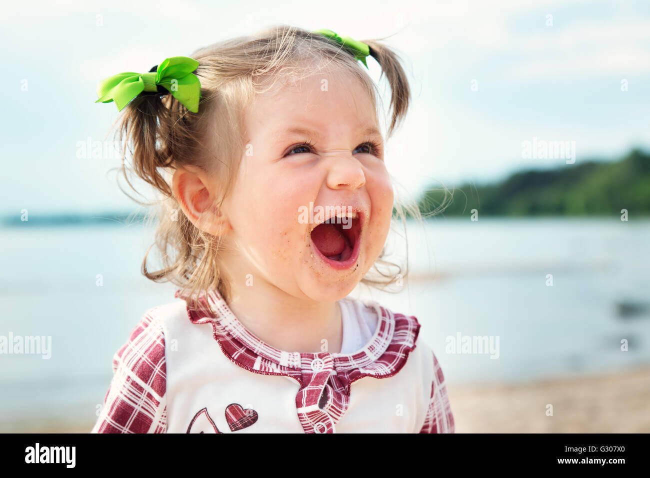 Funny little girl criant à la mer Banque D'Images