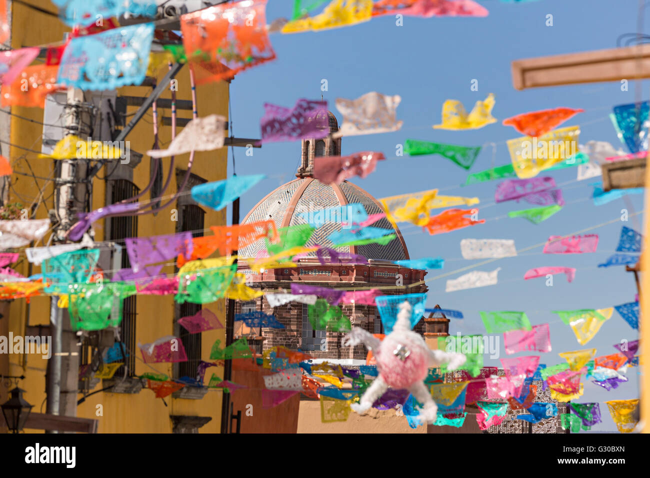 Papel picado bannières fête décorer une rue en regardant vers le dôme de l'Oratorio de San Felipe Neri Eglise dans le centre historique de San Miguel de Allende, Mexique. Banque D'Images