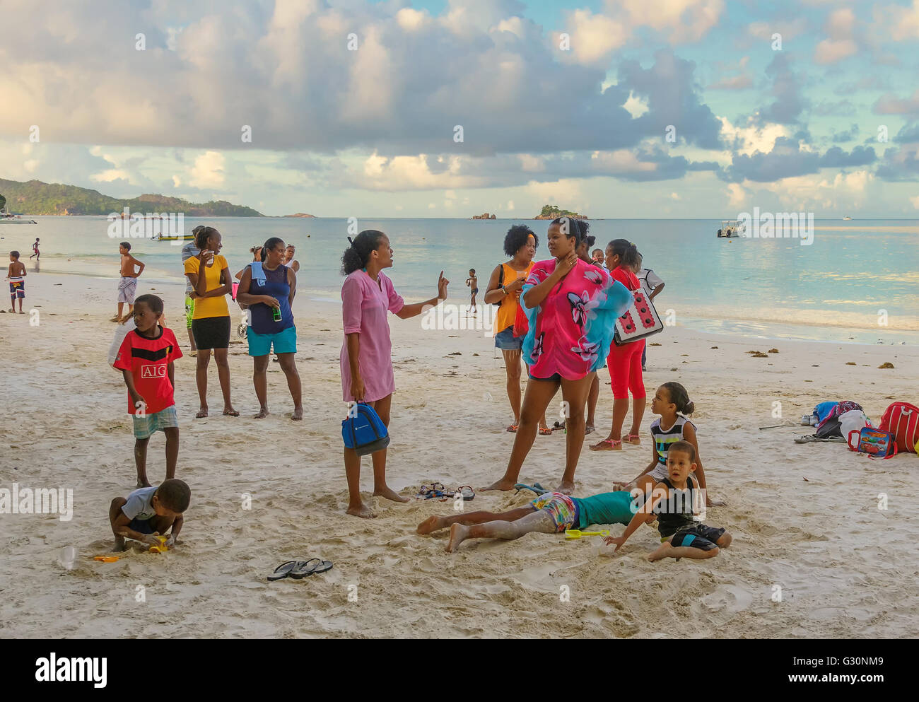 La population locale se détendre le soir à week-end sur la plage de l'île de Praslin, Seychelles Banque D'Images
