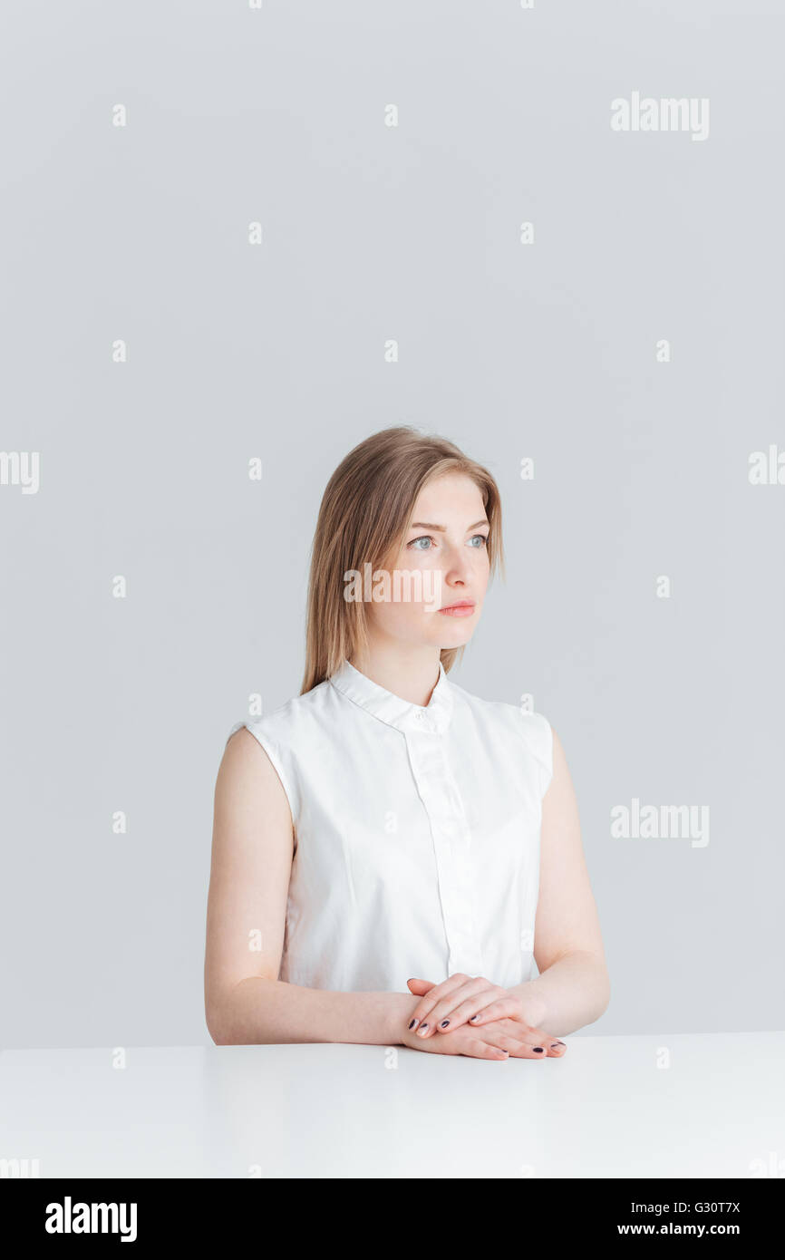 Une jeune femme assise à la table isolé sur fond blanc Banque D'Images