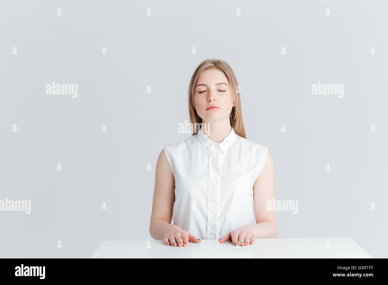 Portrait de femme beauté détendue avec les yeux fermés à la table isolé sur fond blanc Banque D'Images