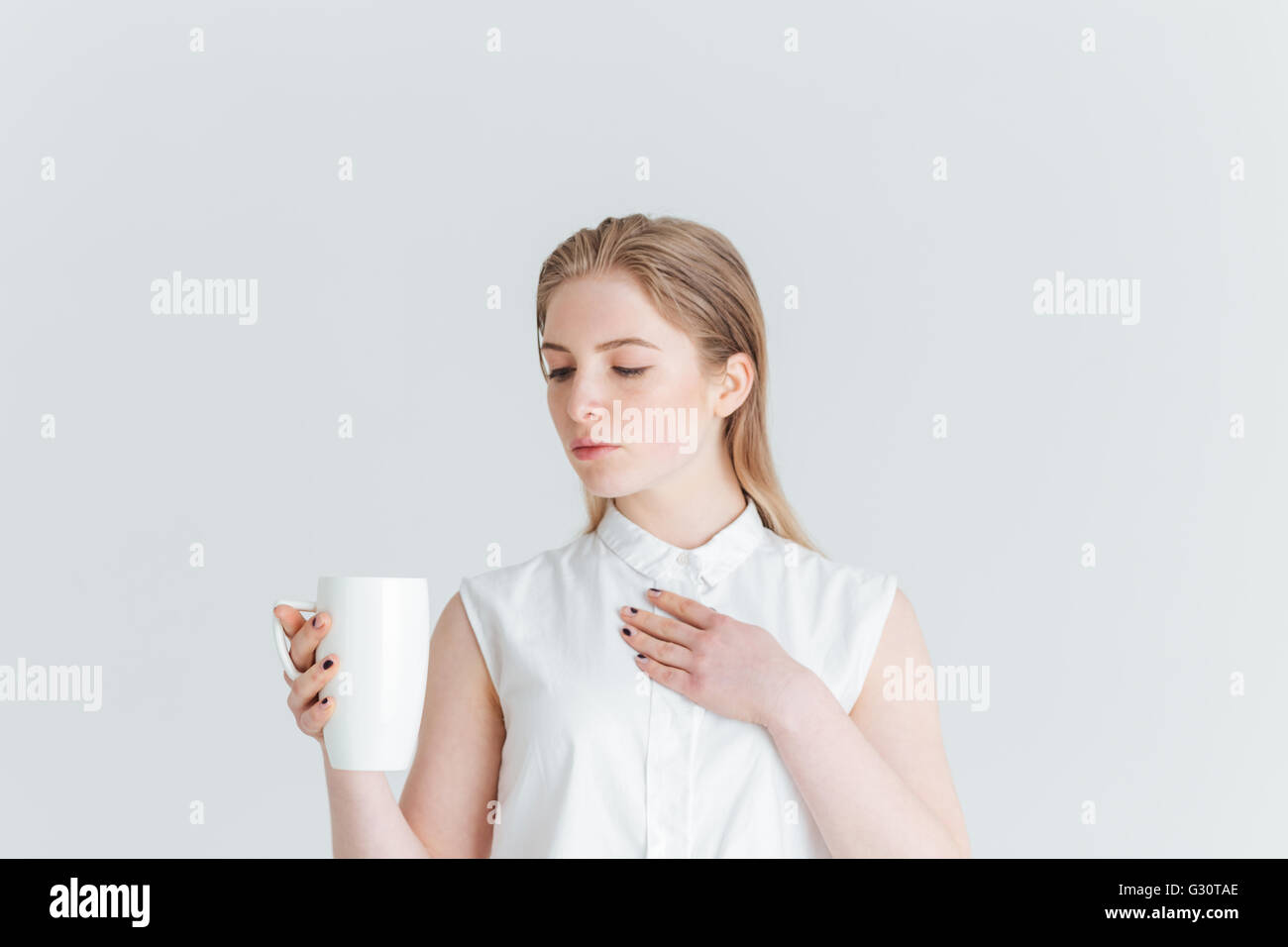 Portrait of a young woman holding cup avec plateau isolé sur fond blanc Banque D'Images