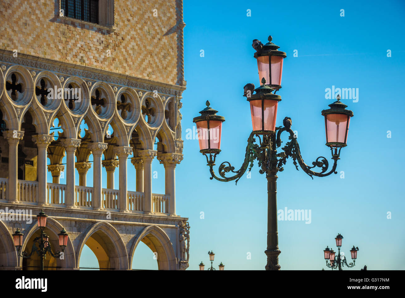 Lampes de rue à Venise avec de nombreux pigeons assis dessus avec ciel bleu sur l'arrière-plan Banque D'Images