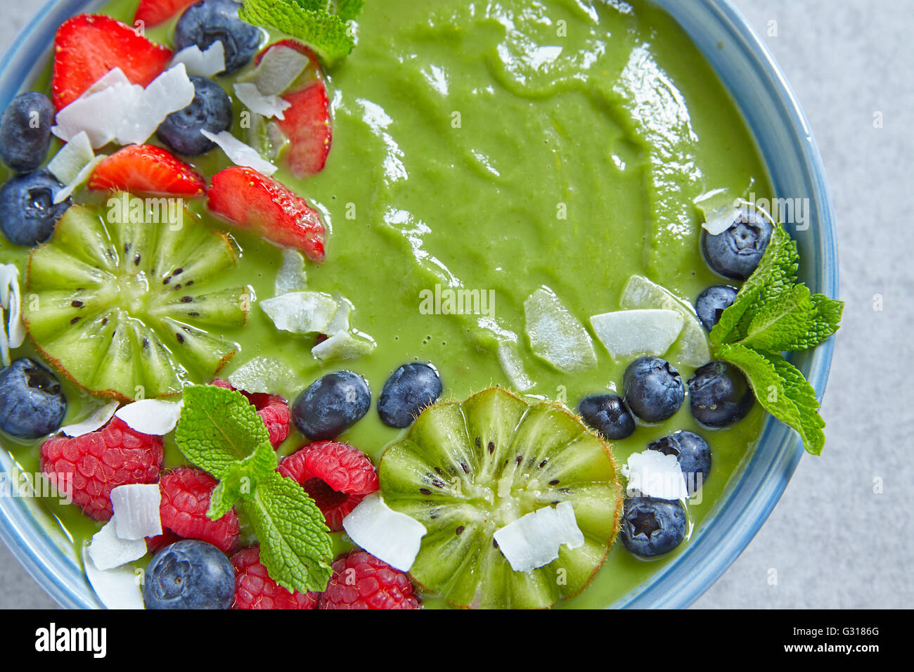 Petit déjeuner smoothie vert coupe de fruits et baies Banque D'Images