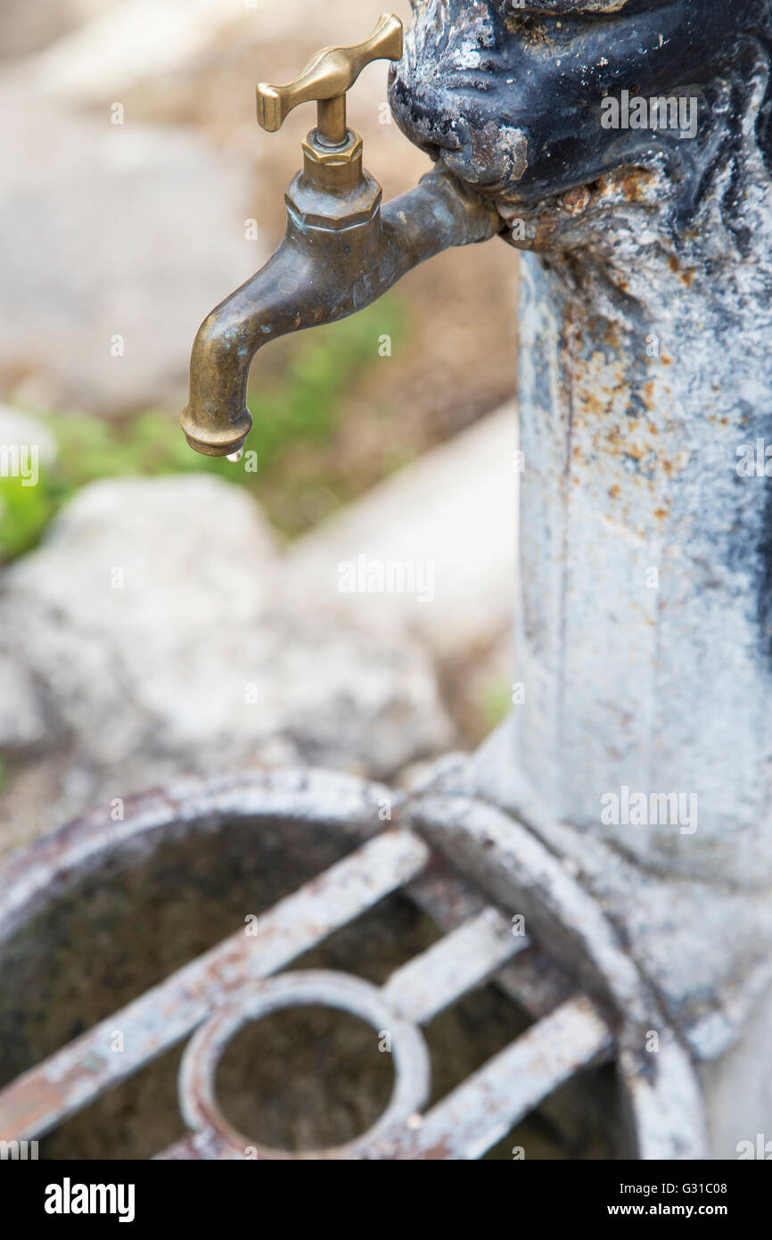 Fer à repasser rusty robinet avec goutte d'eau en gros plan. La rareté de l'eau influe sur chaque continent et autour de 2,8 milliards de personnes autour de th Banque D'Images