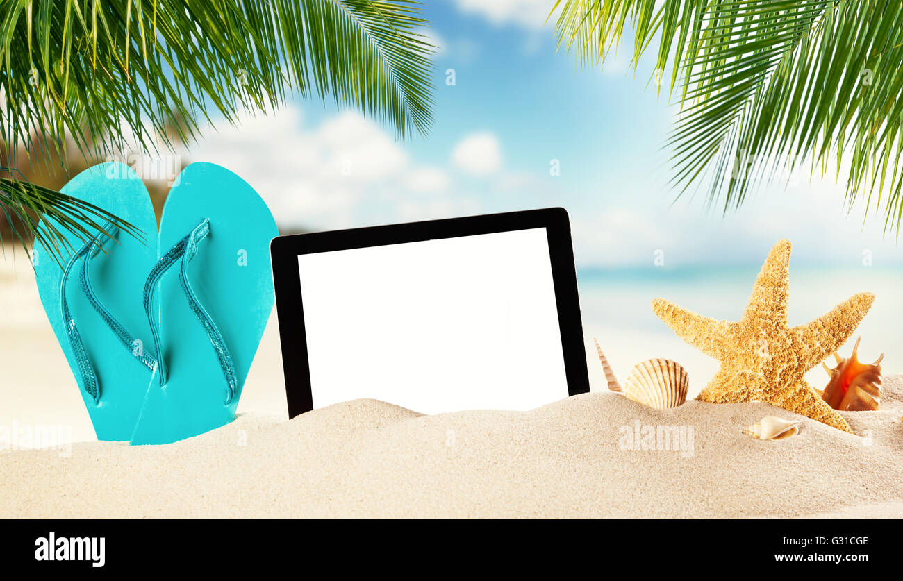 Concept d'été avec tablette pour l'écran vide copyspace. Flipflop bleu et de divers genre d'obus dans le sable. Les feuilles de palmier sur foregro Banque D'Images