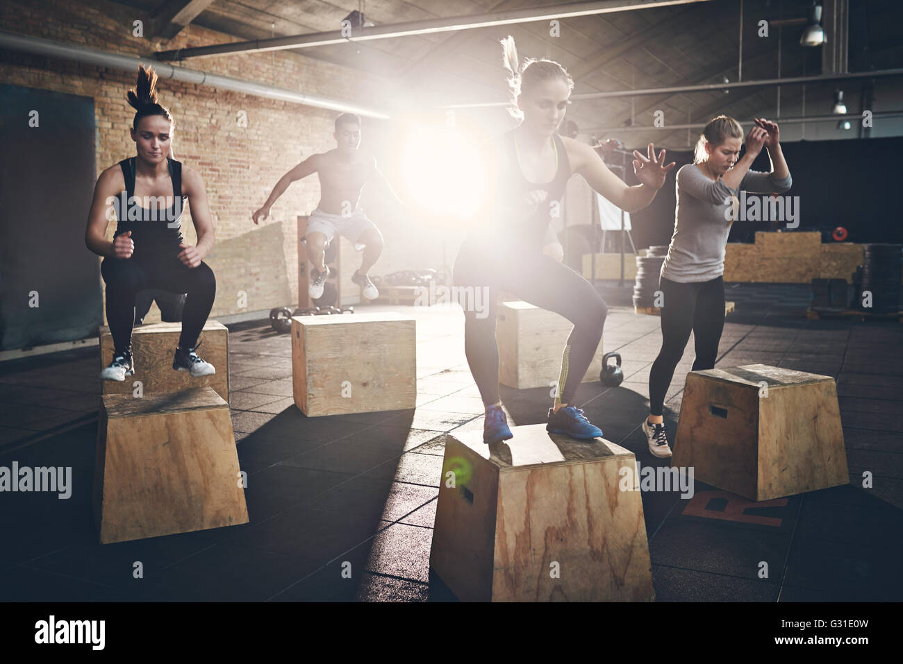 Mettre en place des jeunes faisant fort saute comme un groupe dans une salle de sport Banque D'Images