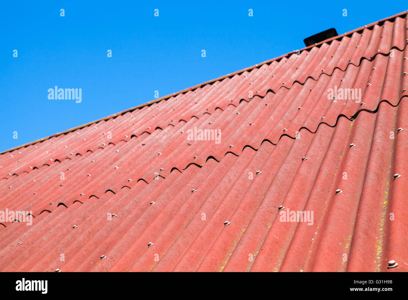 Ciel bleu et toit rouge faite de carton ondulé, texture bitumineux contexte photo Banque D'Images