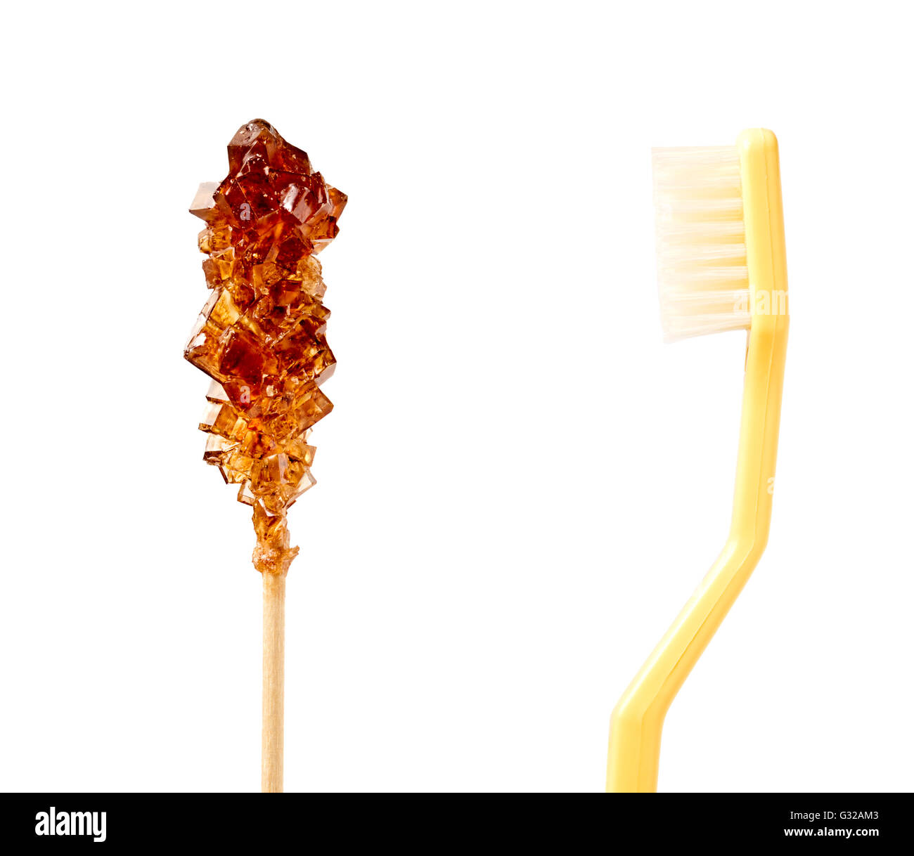 Close up d'un agitateur de sucre brun face à une brosse à dents en soies naturelles isolé sur blanc. Banque D'Images
