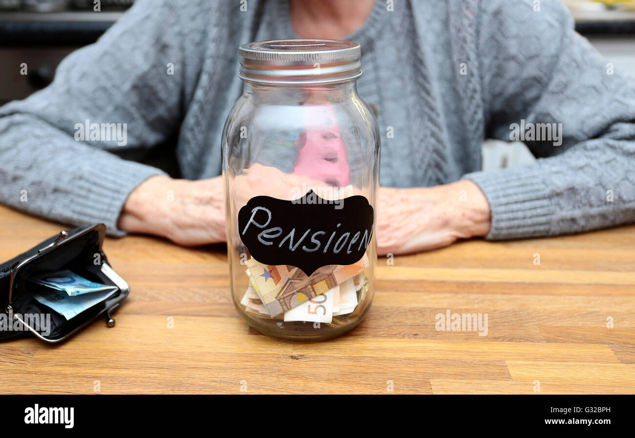 Une femme âgée avec un pot rempli d'argent portant le mot néerlandais pour les régimes Banque D'Images