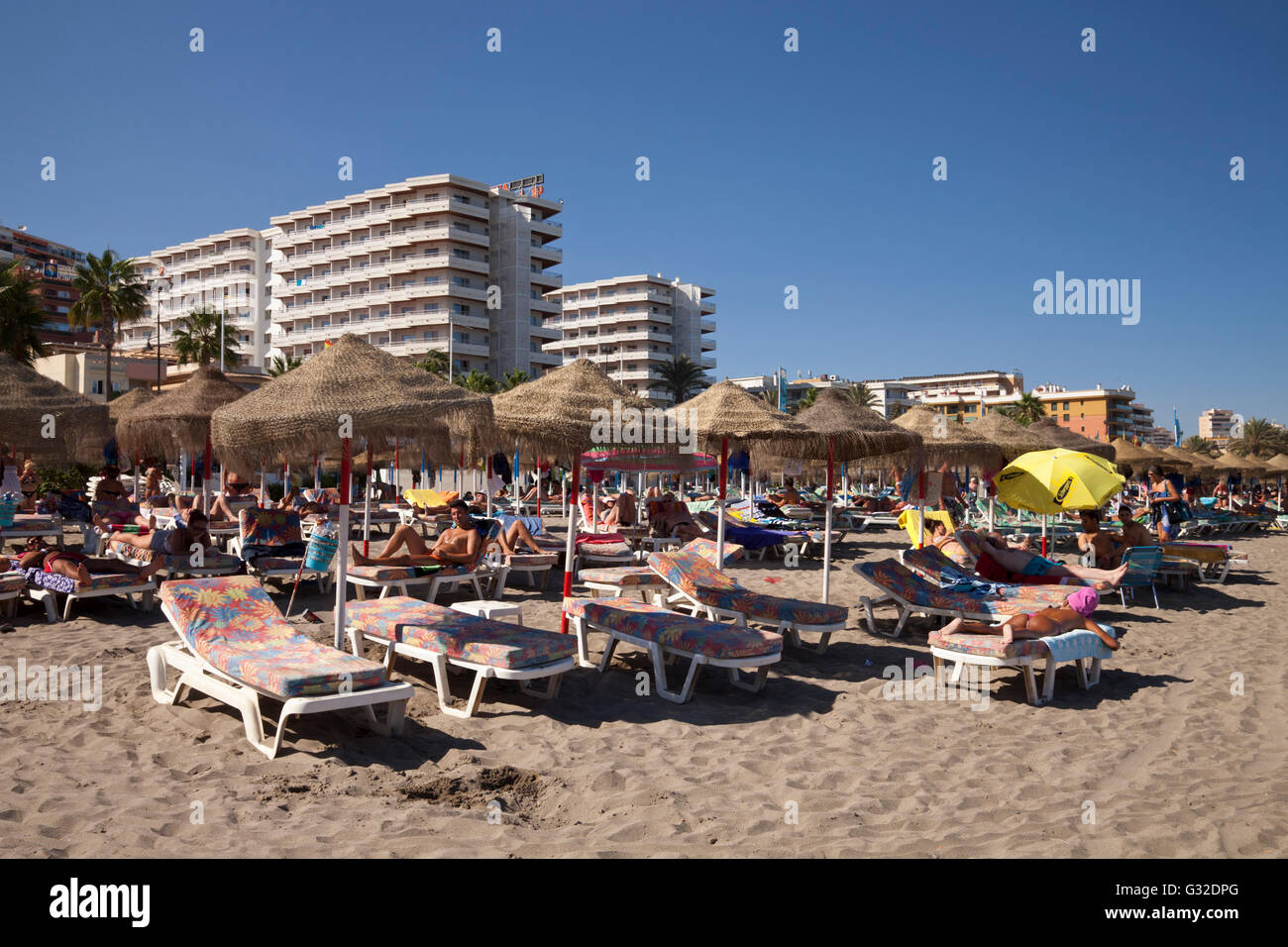 Transats et parasols sur la plage en face de l'hôtel les bâtiments, Torremolinos, la province de Malaga, Costa del Sol, Andalousie, Espagne Banque D'Images