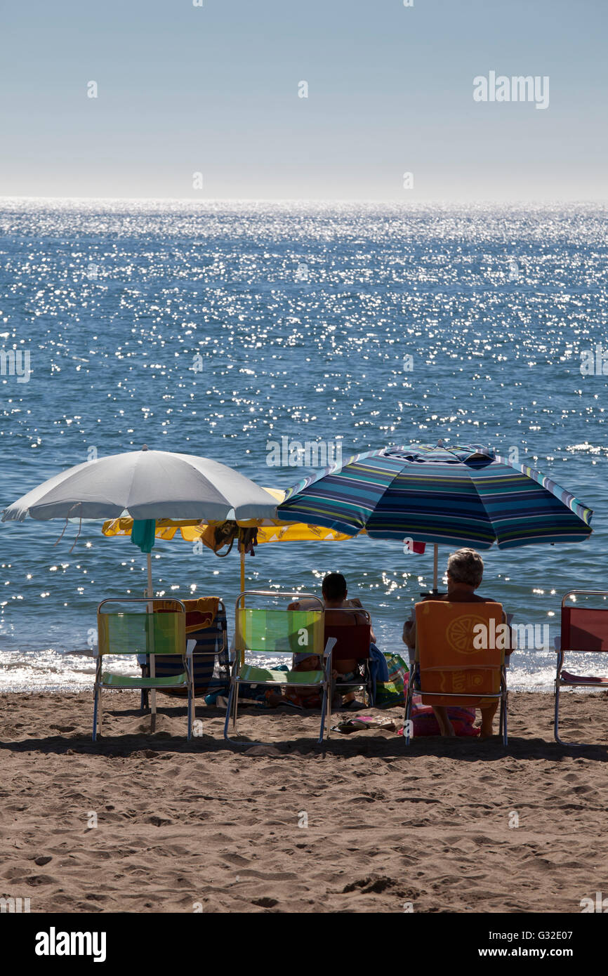 Les touristes à vous détendre sous les parasols sur la plage, de la mer à l'arrière, Fuengirola, Costa del Sol, Andalousie, Espagne, Europe Banque D'Images