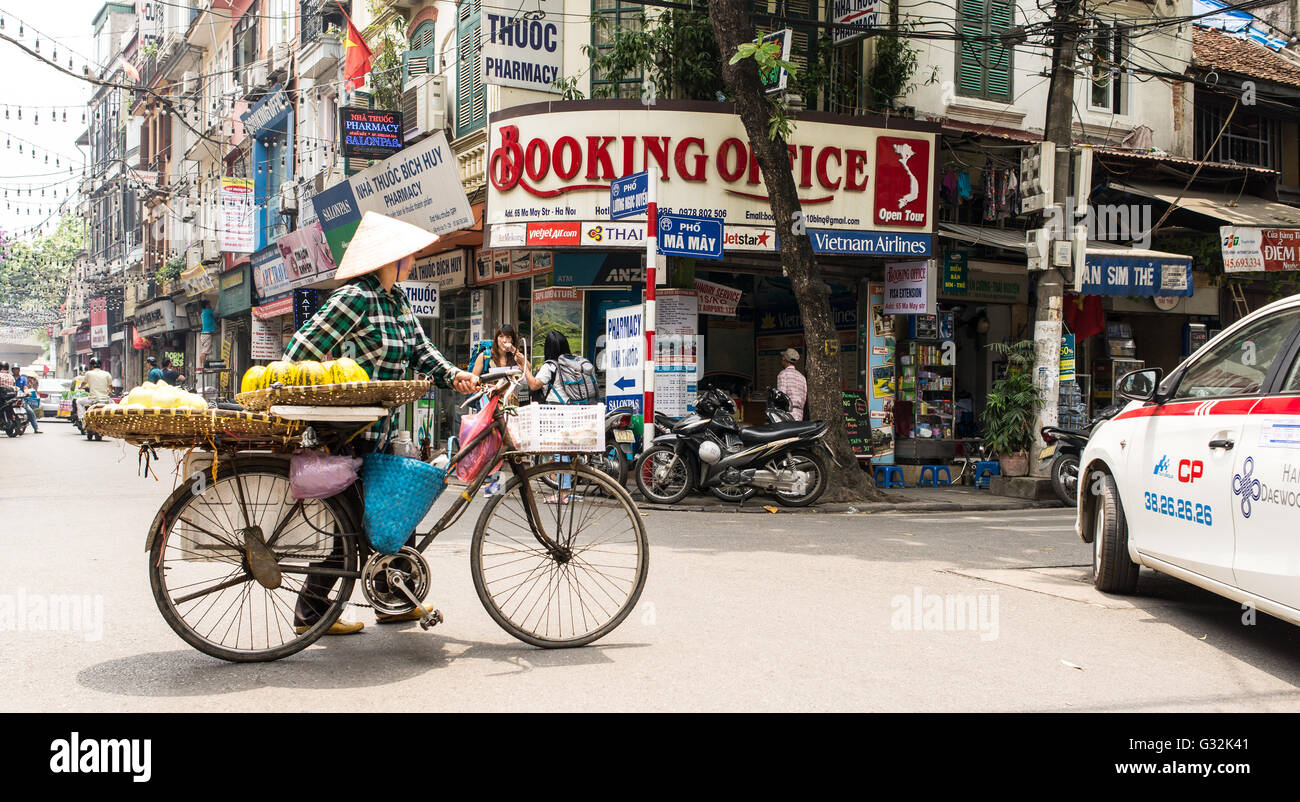 Vendeur de rue en utilisant un vélo pour transporter des légumes et des fruits dans la vieille ville d'Hanoi. Banque D'Images
