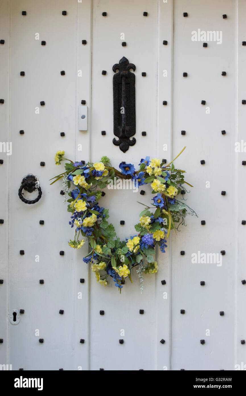 Printemps coeur floral couronne sur une porte cloutée en bois blanc. Arles, France Banque D'Images