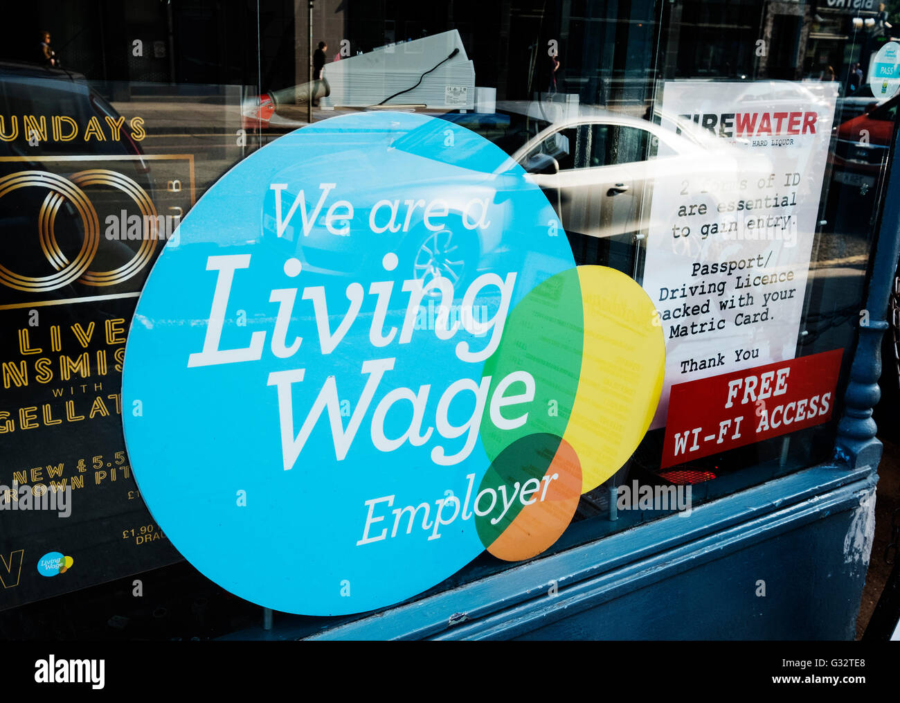 Ouvrir une fenêtre de pub indiquant que les employés sont payés un salaire de subsistance à Glasgow, Ecosse, Royaume-Uni Banque D'Images