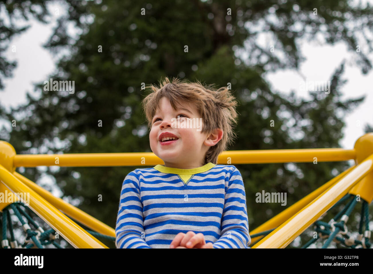 Portrait of a smiling boy sur l'escalade en aire de jeux Banque D'Images