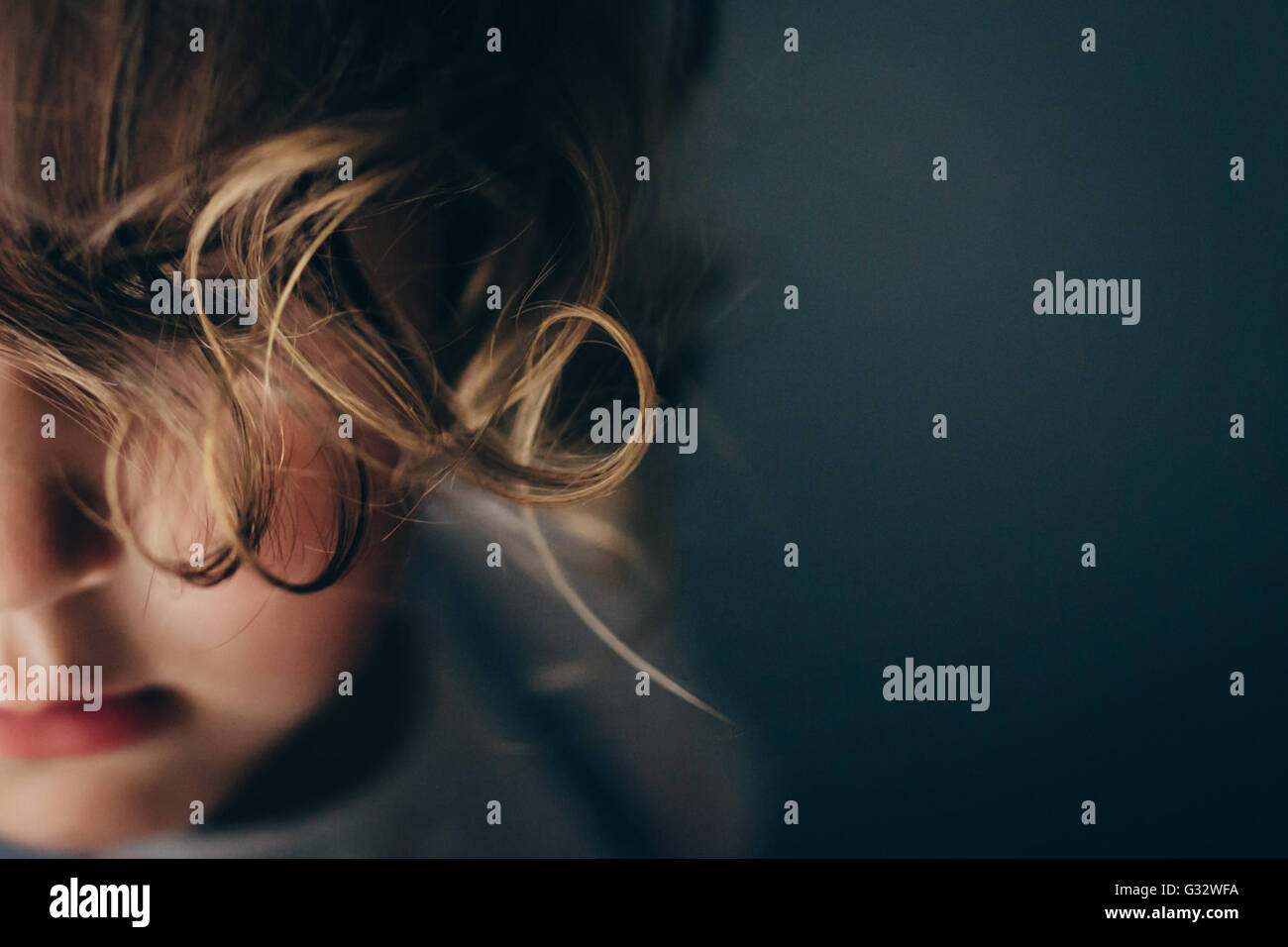 Close-up Portrait of Girl with curly hair covering face Banque D'Images