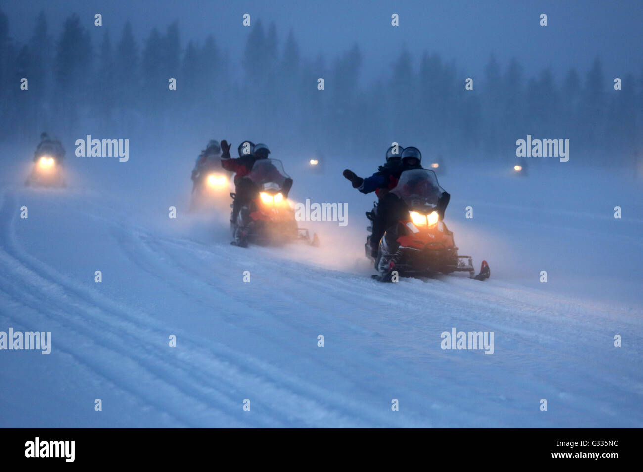 ?K skero, en Finlande, les hommes sont la conduite de nuit sur les motoneiges Banque D'Images