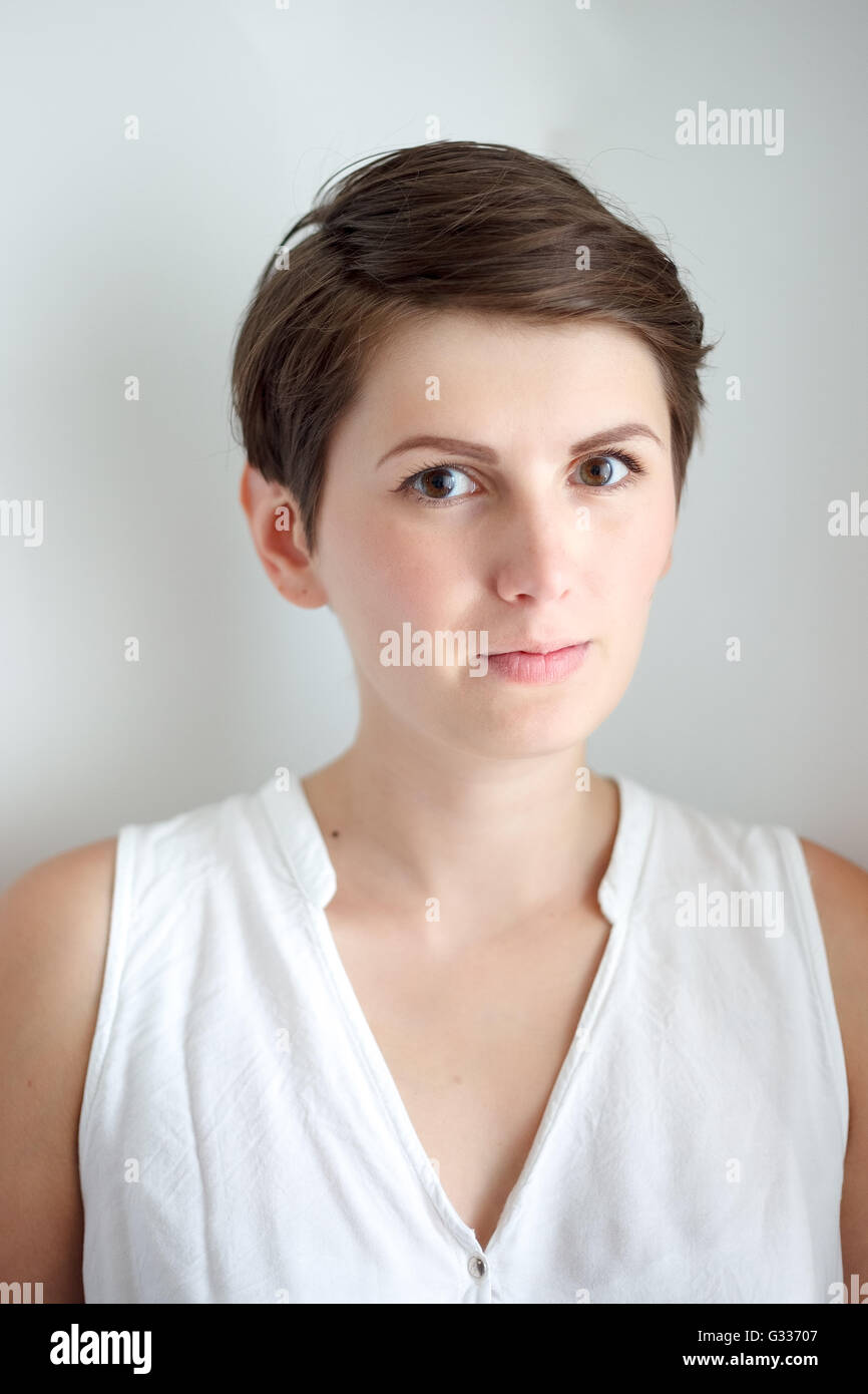Cheveux courts charmante jeune femme sans maquillage sur fond blanc Banque D'Images