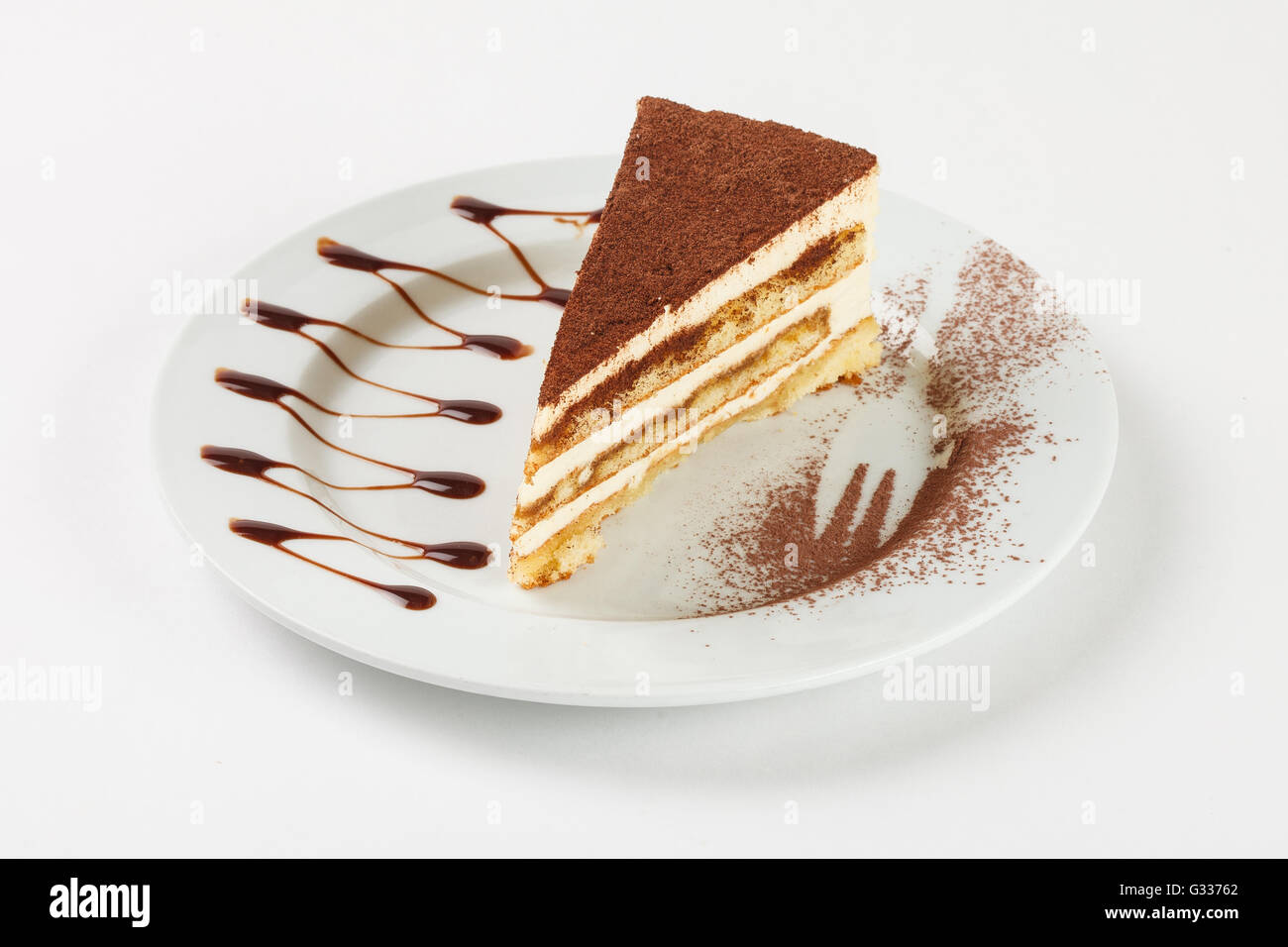Crème de chocolat délicieux gâteau sur la plaque sur fond blanc. Close up Vue de côté. Banque D'Images
