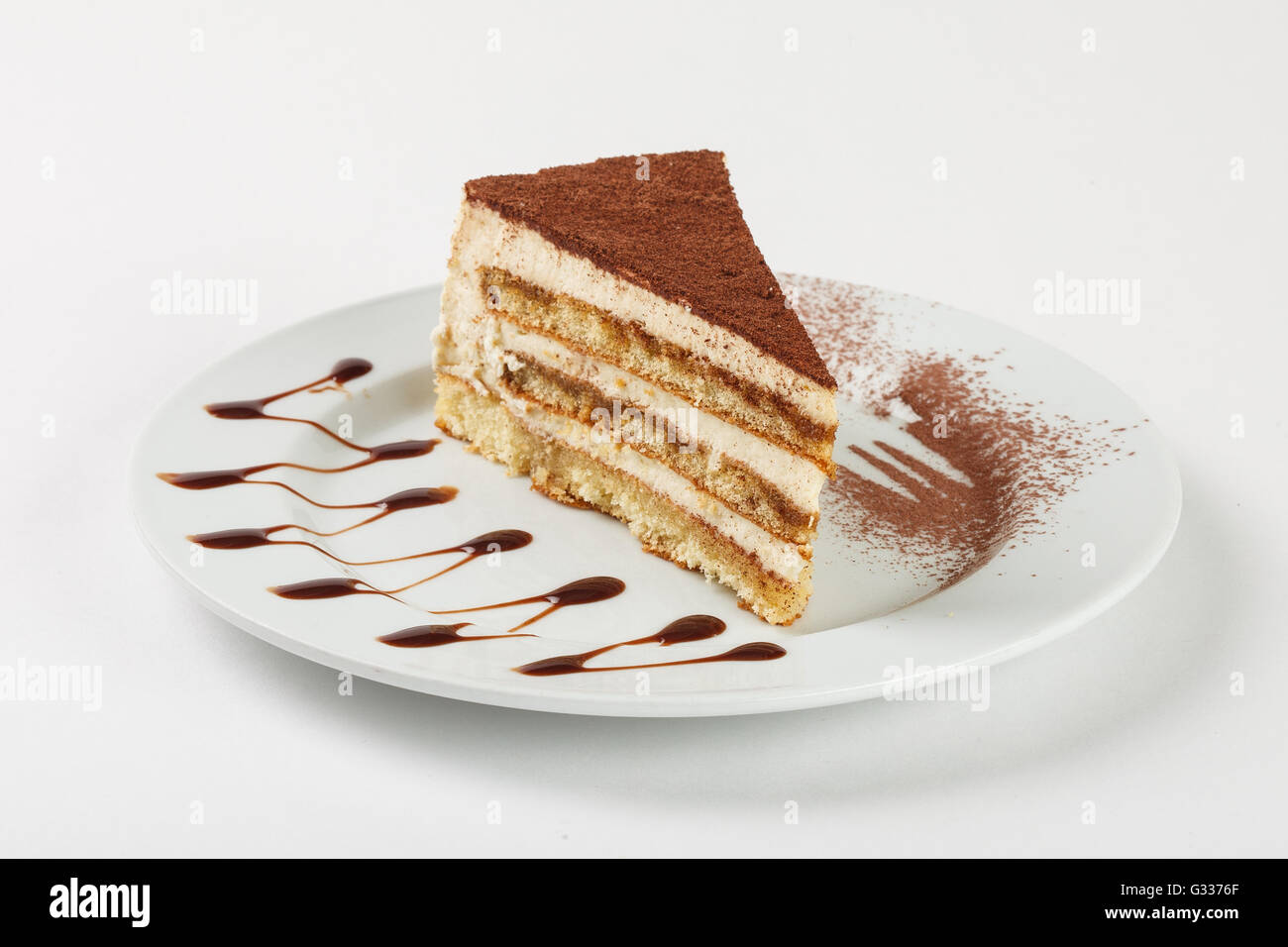Crème de chocolat délicieux gâteau sur la plaque sur fond blanc. Close up Vue de côté. Banque D'Images