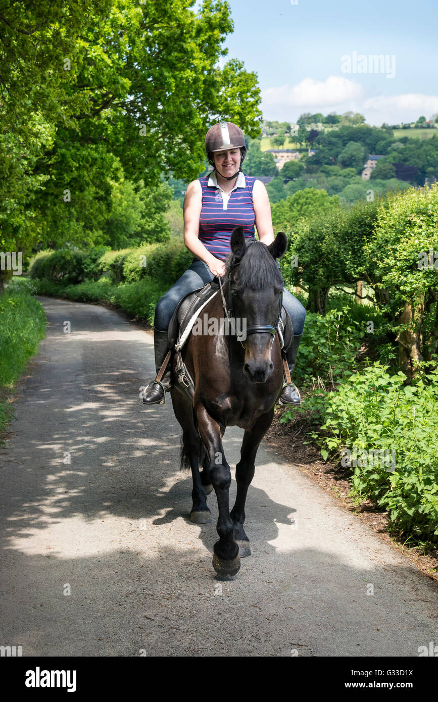 Horse Rider sur un chemin de campagne dans la campagne anglaise. Un jour d'été ensoleillé. Banque D'Images