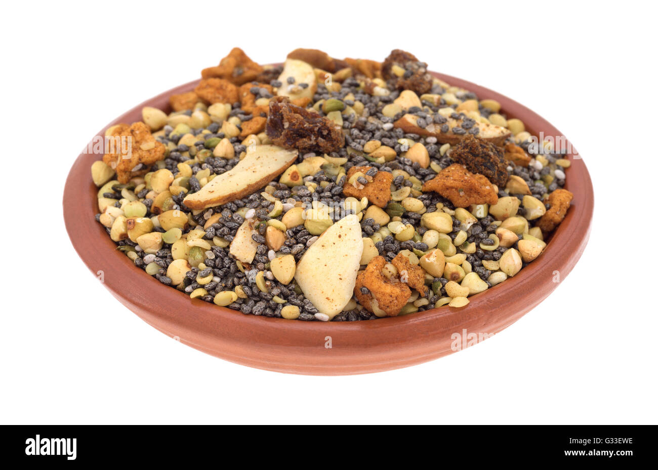 Un petit bol rempli de céréales à déjeuner sèches composé de graines de chia, noix, fruits secs et isolé sur un fond blanc. Banque D'Images