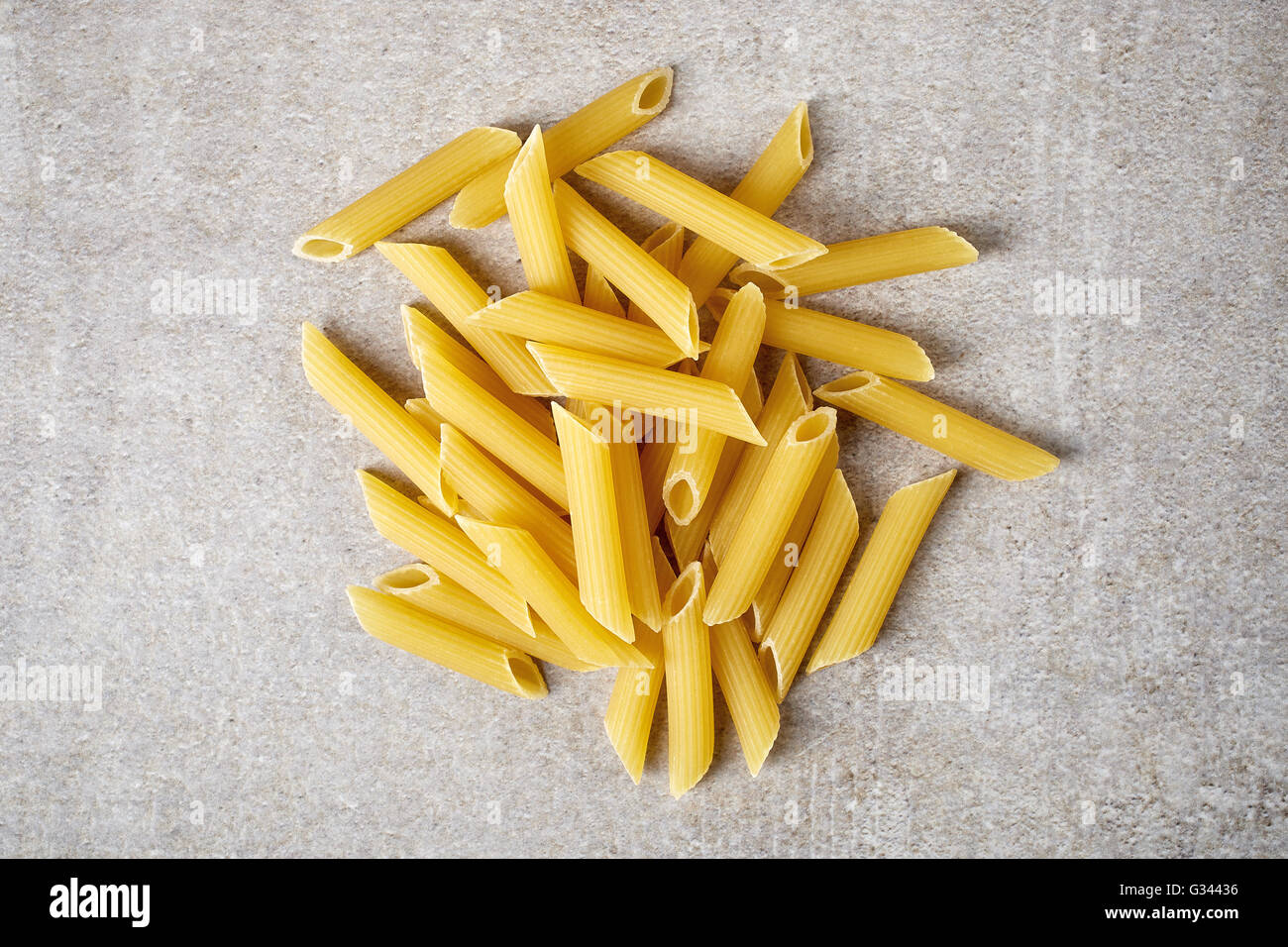 Pâtes penne sur table en pierre, vue du dessus Banque D'Images