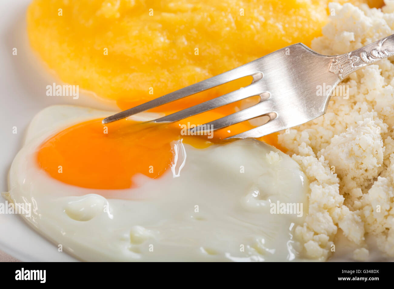 Manger la polenta avec œuf et fromage sur la plaque Banque D'Images