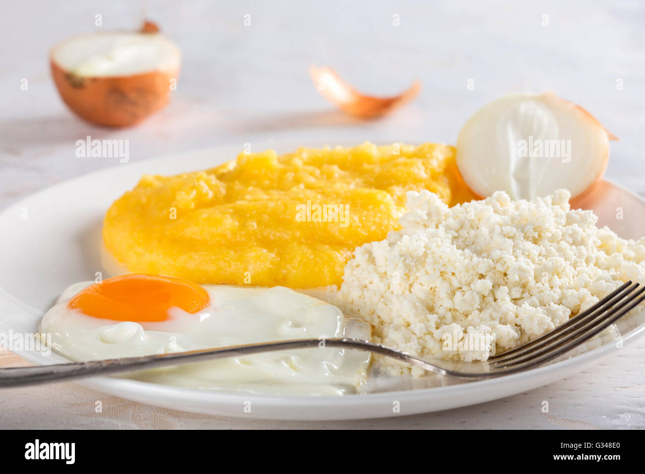 La polenta avec des œufs, du fromage et l'oignon sur la plaque Banque D'Images