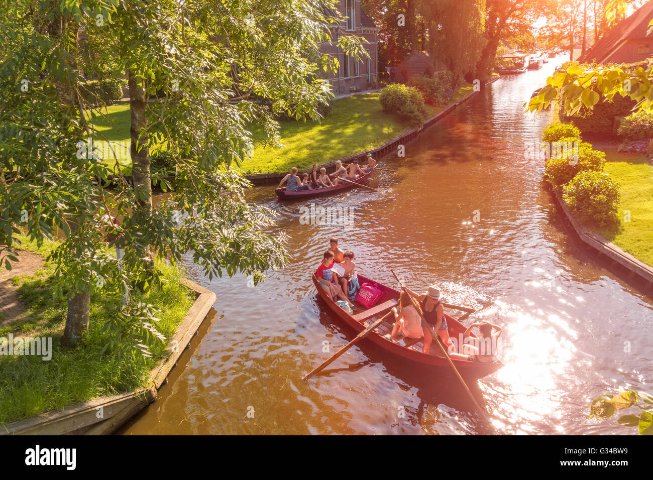 Giethoorn, Pays-Bas. Les enfants et l'aviron barque bateaux traditionnels dans le canal Dorpsgracht ou le village de Giethoorn Banque D'Images