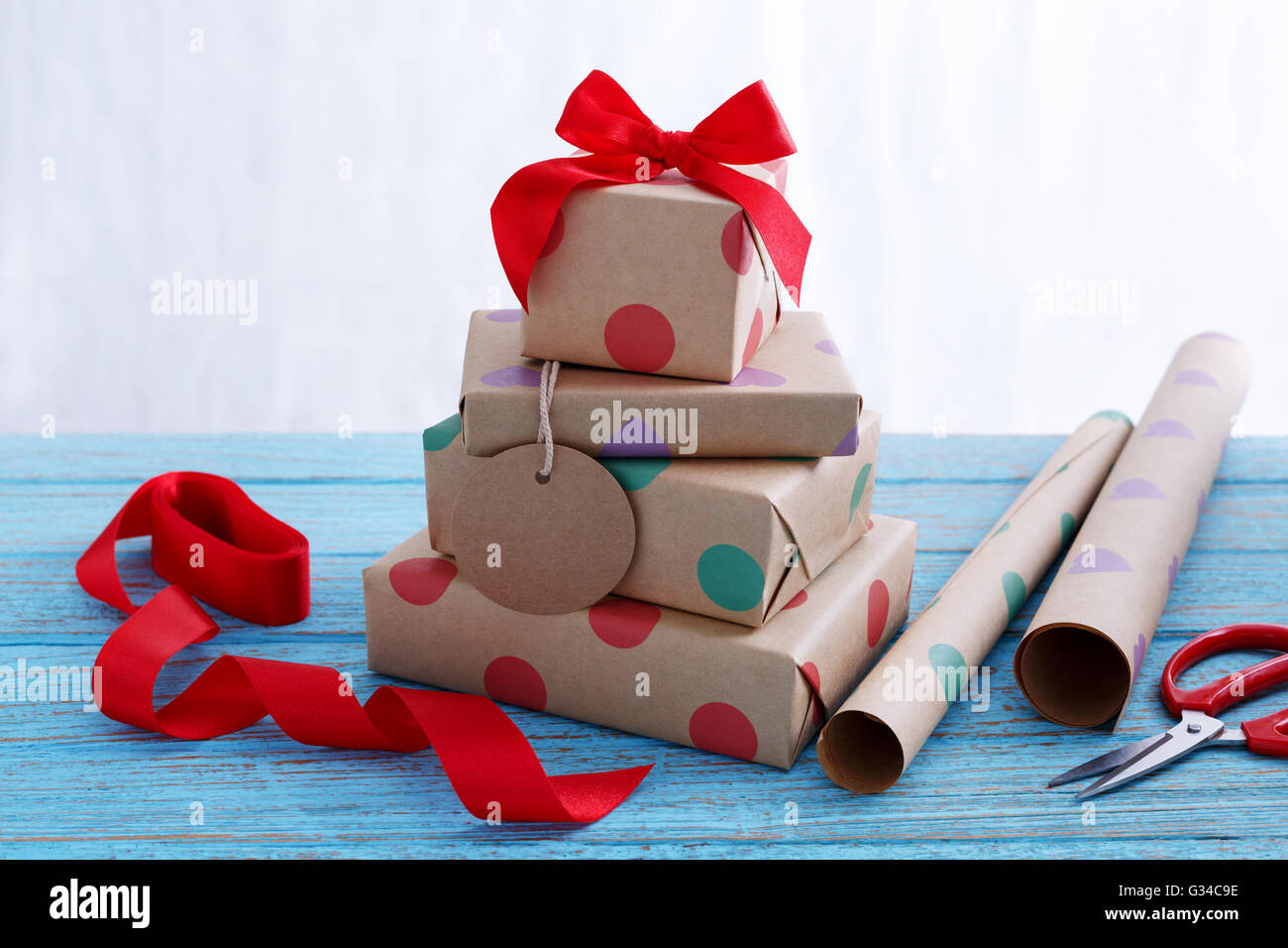 Cadeaux pour anniversaire avec du papier d'emballage et ruban rouge sur la table en bois Banque D'Images