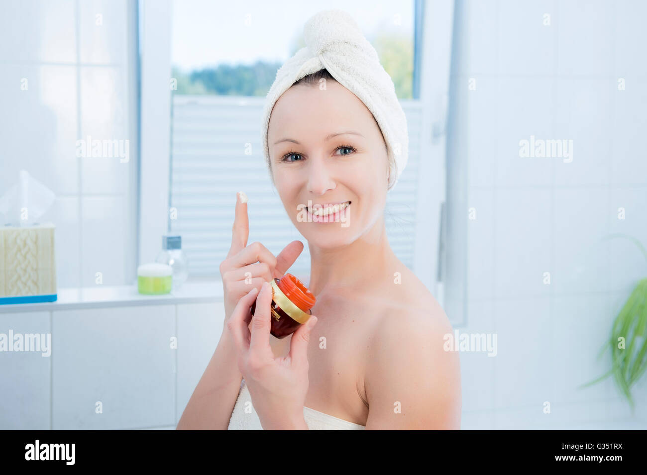 Femme, 30 +, dans la salle de bains l'application facial care Banque D'Images