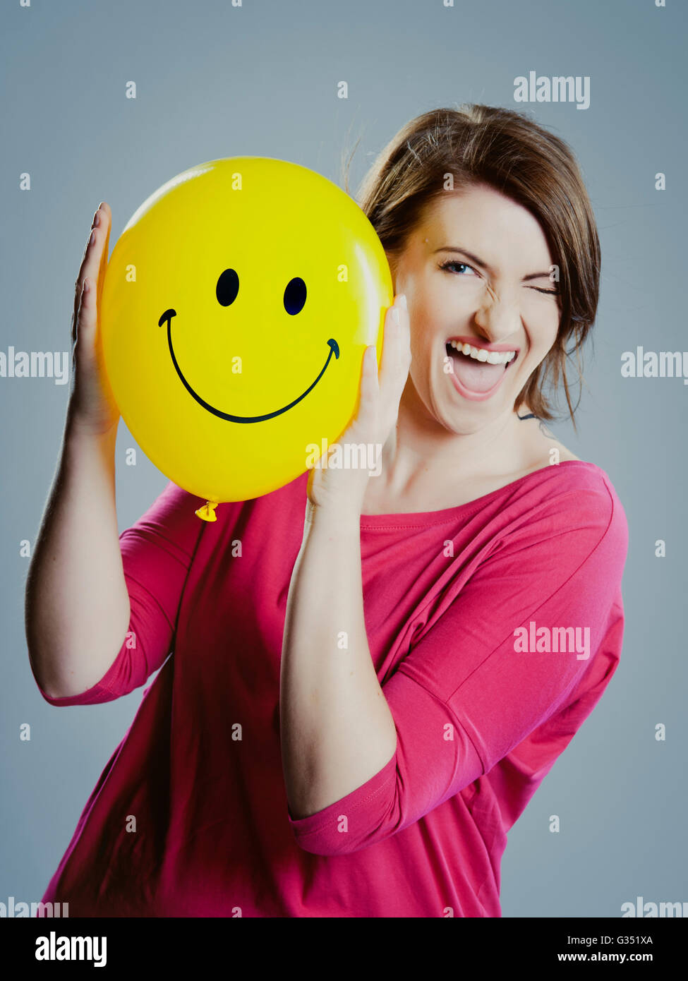 Jeune femme smiley face balloon Banque D'Images