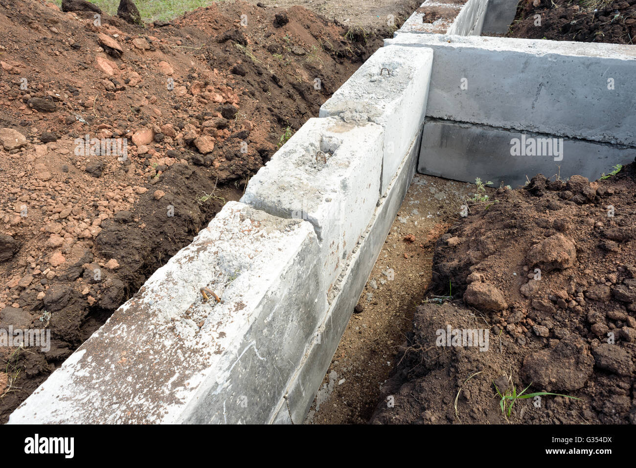 Blocs de construction en béton construction gris utilisé pour les fondations d'une auto-construction maison. Pour les tranchées et creusé hors terre entourent Banque D'Images