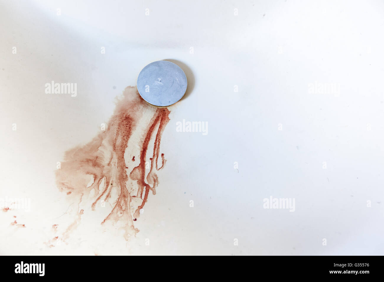 Des gouttelettes de sang en descendant le drain dans un puits domestique Banque D'Images