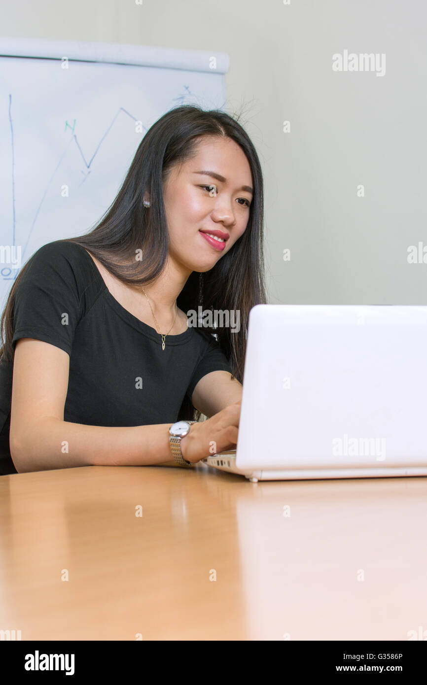 Beautiful asian woman working on a laptop Banque D'Images